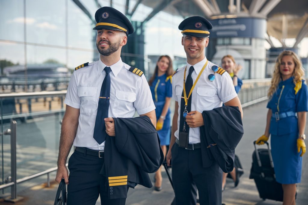 Cheerful pilots and stewardesses standing on the street