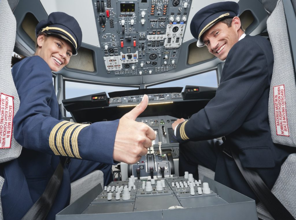Happy Pilot and co-pilot piloting aeroplane from airplane cockpit