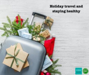 A suitcase surrounded by holiday decorations, gifts, and face masks, placed on a light-colored surface. Text reads "Holiday travel and staying healthy.