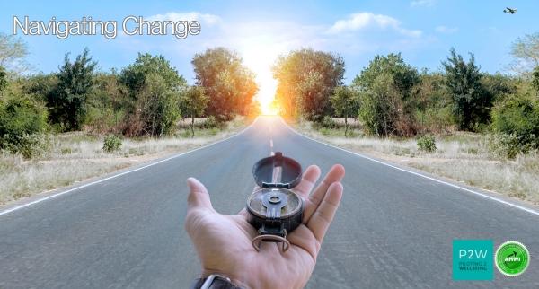 A person holds a compass on an open road leading towards a bright light at the horizon, with the text "Navigating Change" in the sky.