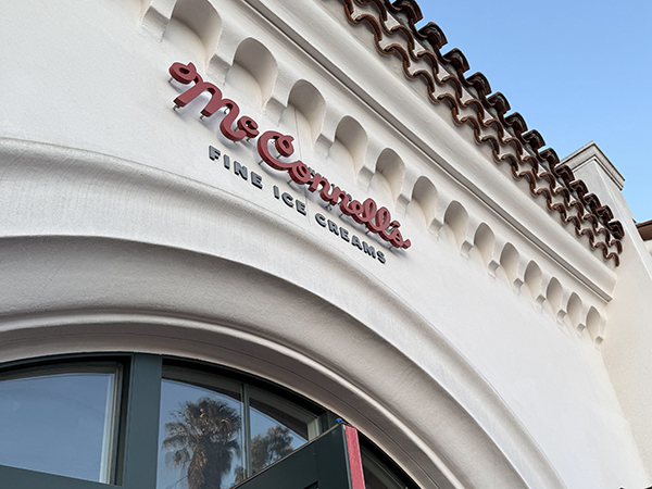 Exterior of a building with "McConnell's Fine Ice Creams" sign on a white facade and arched entrance.